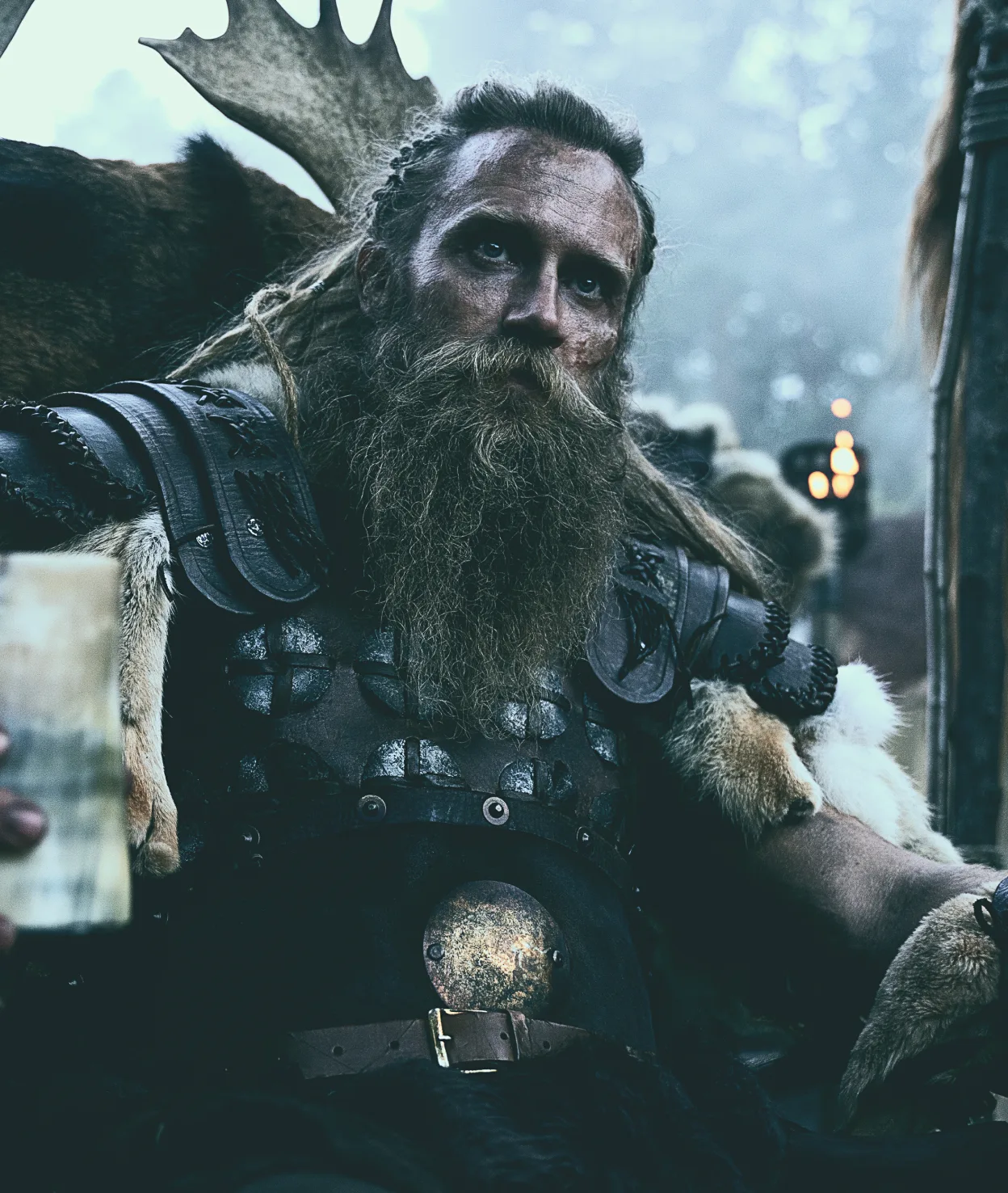 A bearded warrior in leather armor, a drinking horn in hand